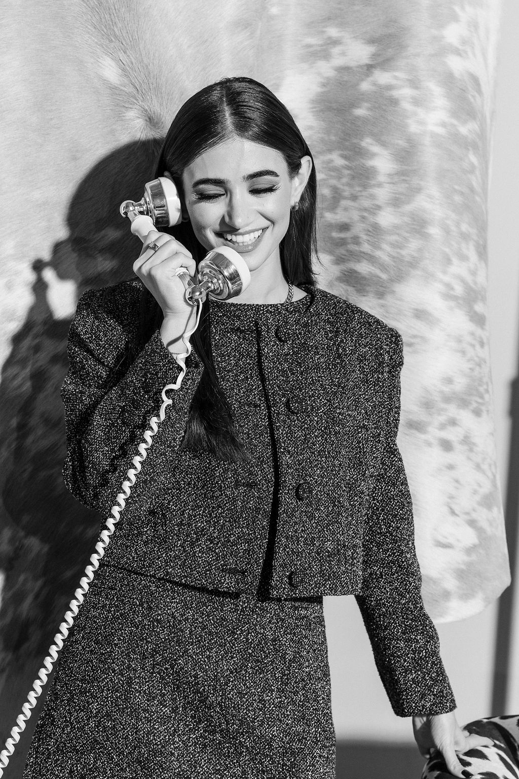 Nancy smiling while holding a vintage telephone, representing client support at Kadeema Rentals