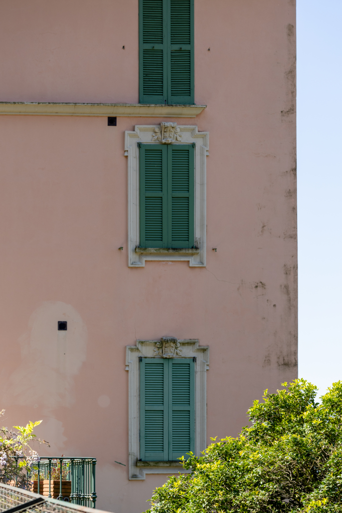 Pink villa facade with green shutters in Lake Como, Italy
