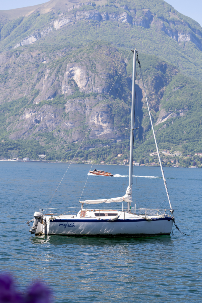 Sailboat on Lake Como with mountains rising behind the water, Italy
