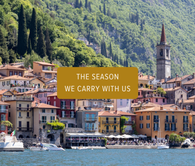 Colorful lakeside village in Lake Como, Italy, surrounded by lush green mountains and viewed from the water.