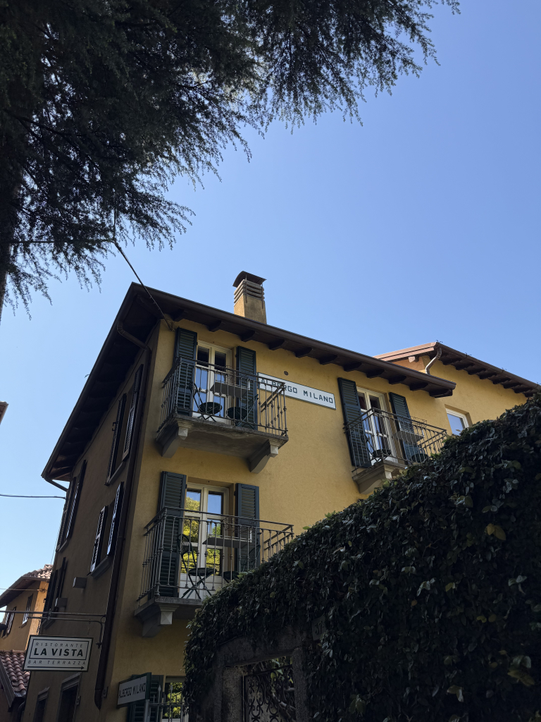 Historic building with balconies and ivy along a street in Lake Como, Italy
